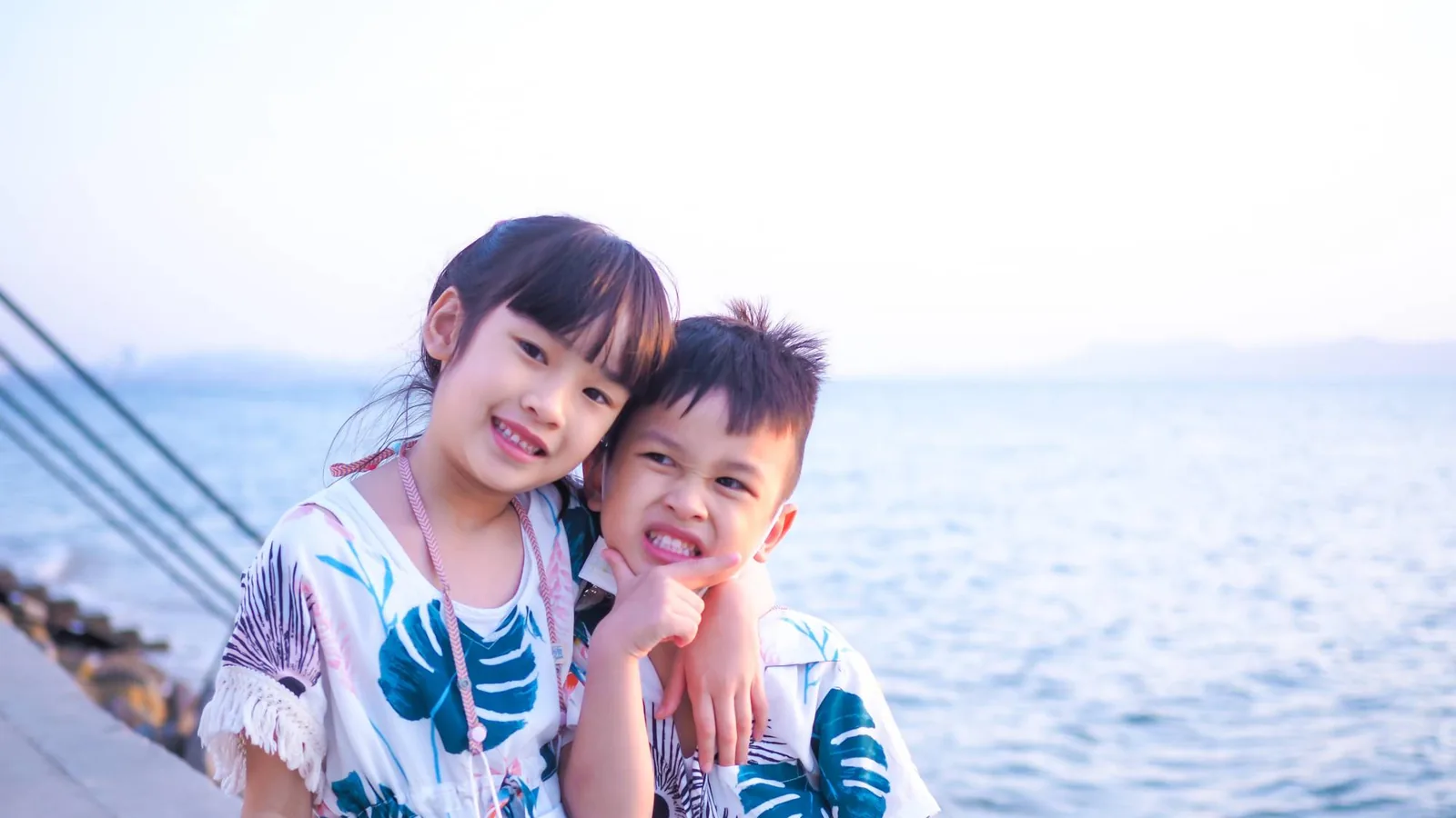 Children smiling and waving in the grounds of a participating business